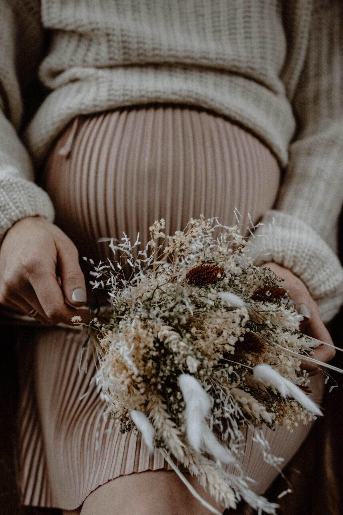 Schwangere Frau mit Trockenblumen beim Mother Blessing
